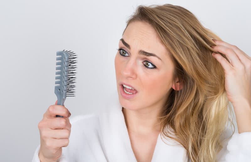 Worried Woman Looking At Comb