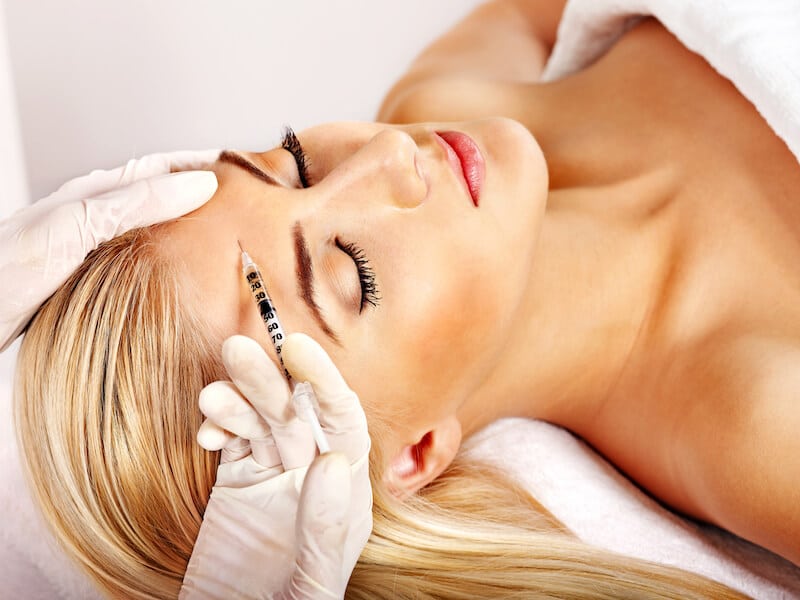 Woman giving prp facial injections.